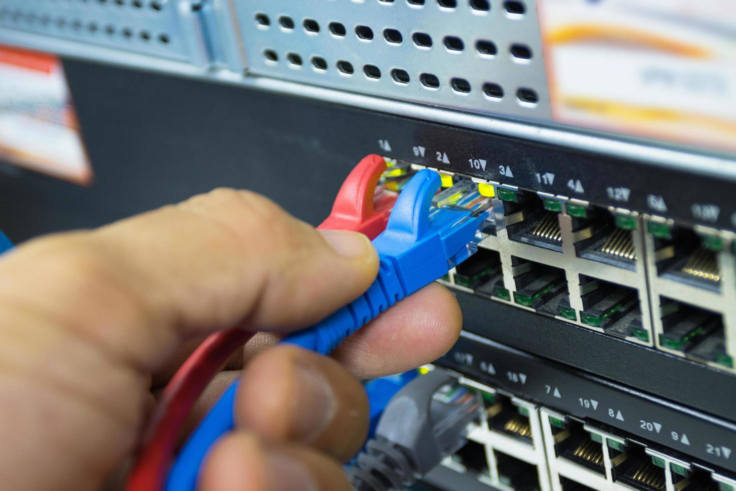 mano del hombre que sostiene los cables de red para conectar el puerto lan, tecnología de conexión de comunicación conceptual foto