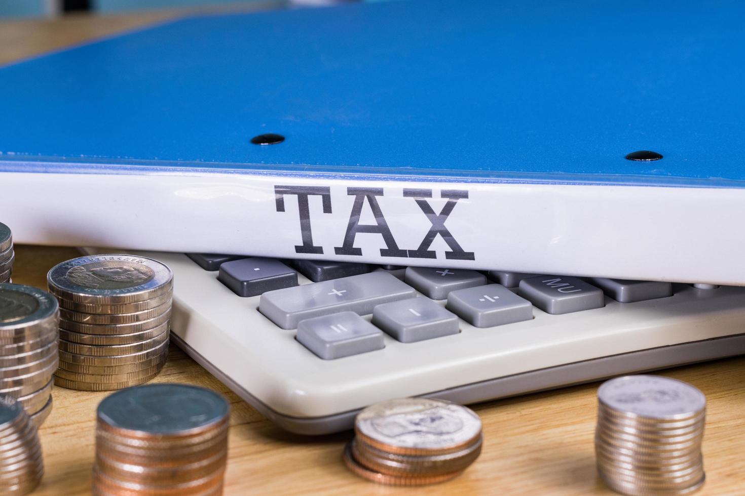 Folder Tax documents and stack of coin with calculator, concept Annual tax payment at work office photo