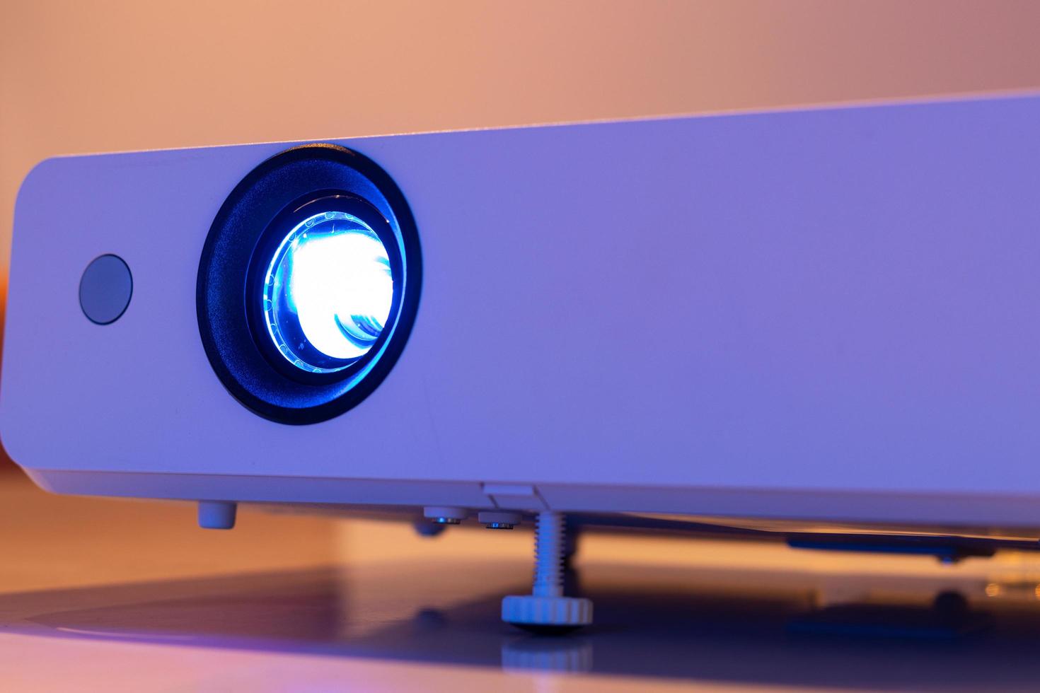 close up the lens of the projector with light for presentation in a dark room presention photo