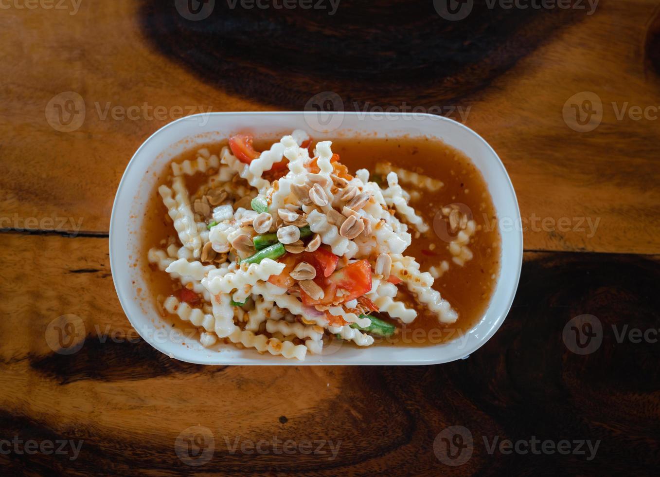 top view of sliced young coconut Thai style spicy salad or Som Tam on wooden table photo