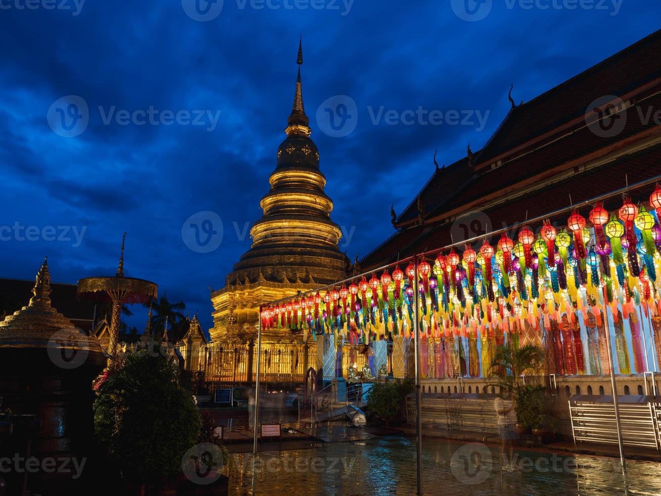 Hundred thousand lantern festival in Lamphun Buddhist worship at Wat Phra That Hariphunchai temple with dark blue sky photo