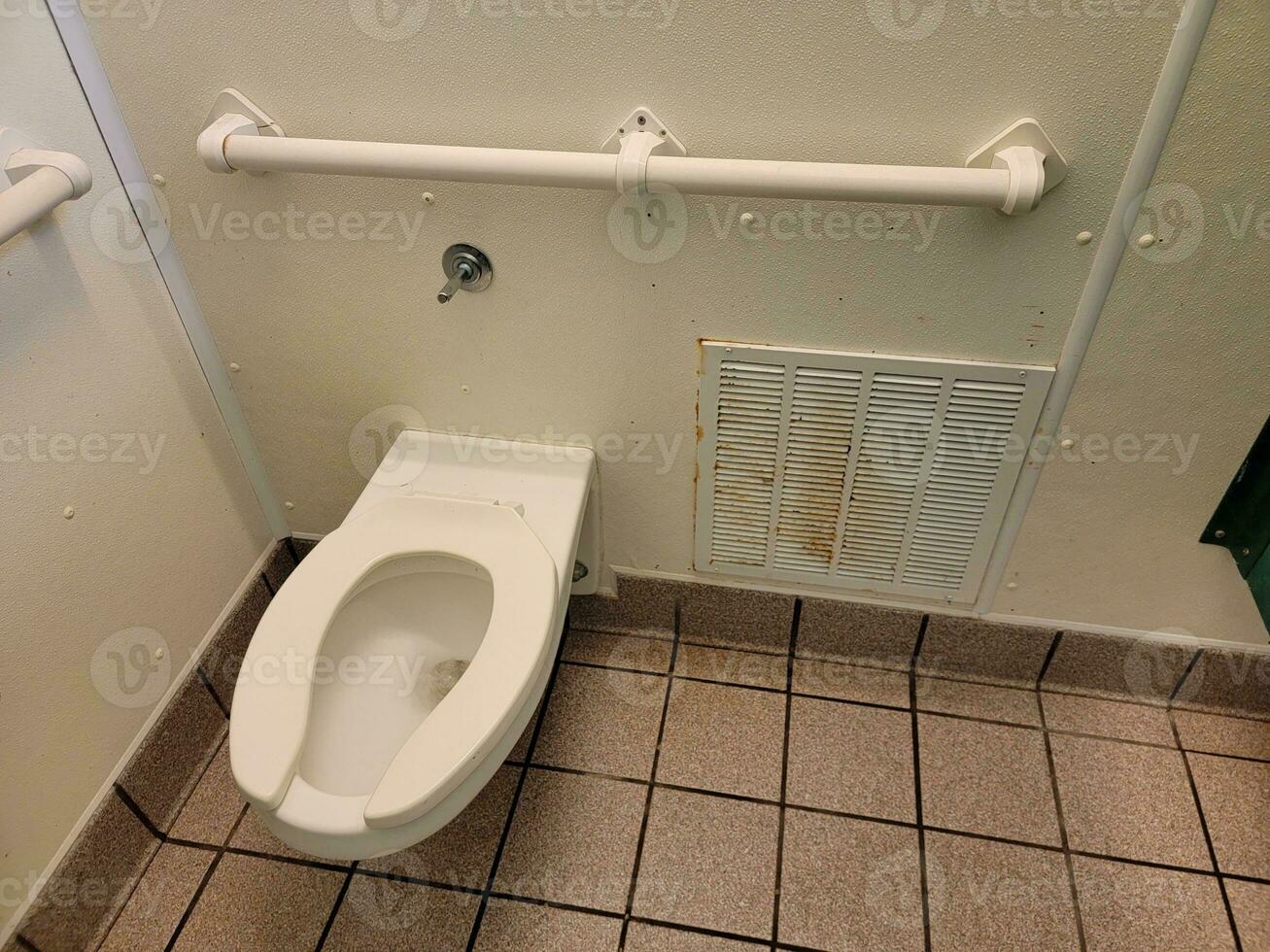 toilet and rusty heater in bathroom or restroom stall photo