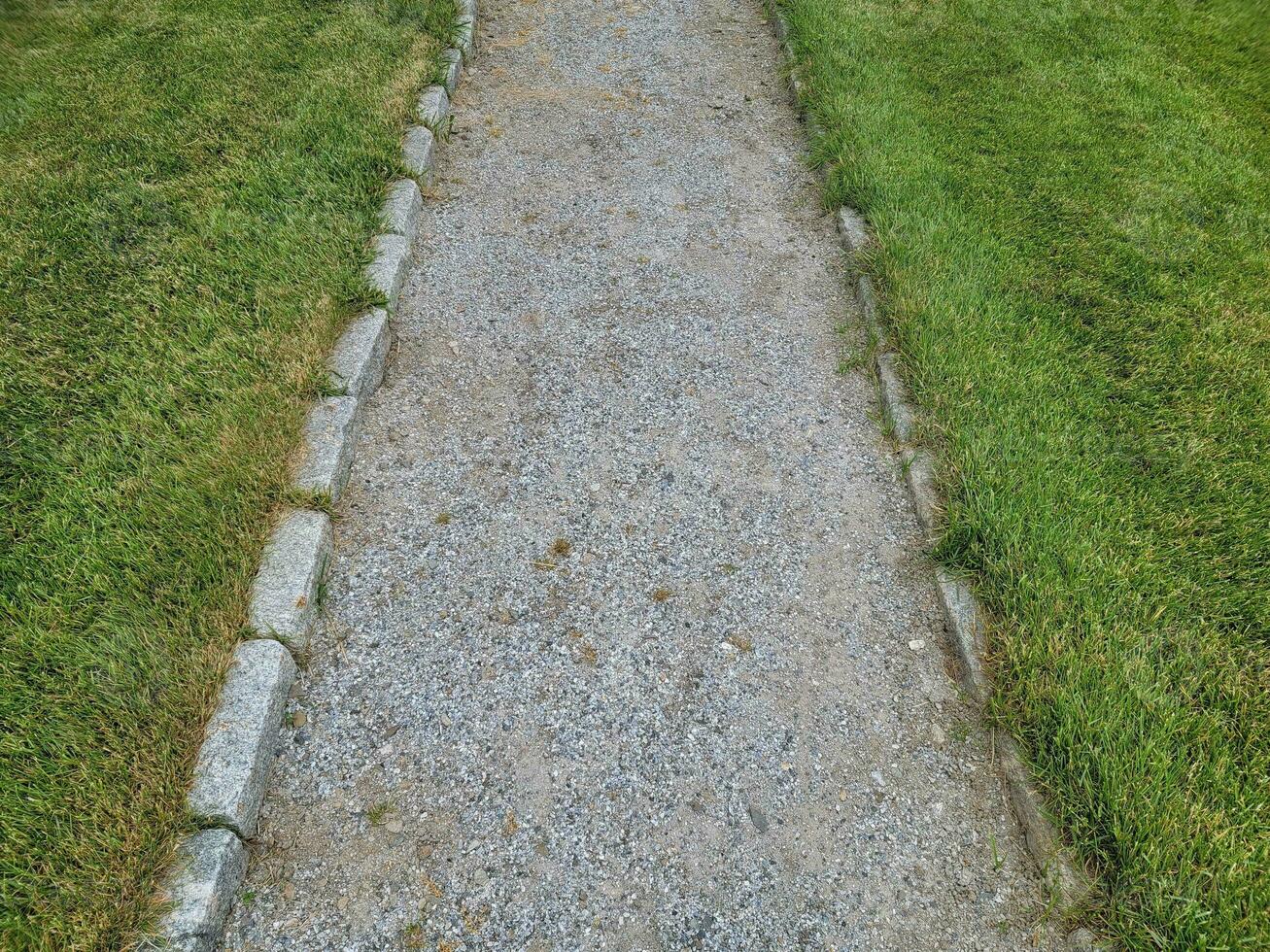 grey stone or gravel path with green grass or lawn photo