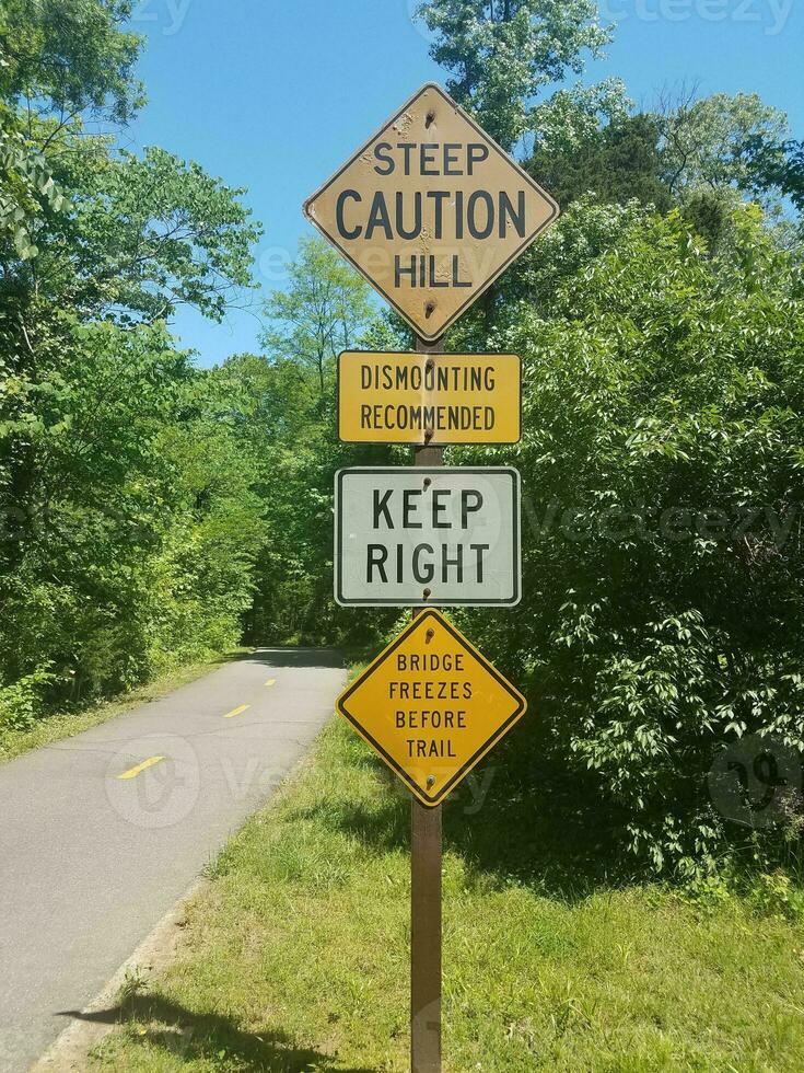 asphalt bike path with steep hill and caution signs photo