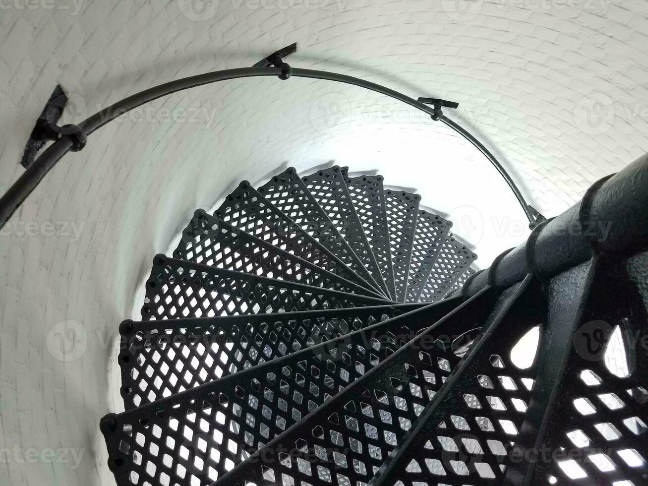 black iron metal spiral staircase and white wall in lighthouse photo