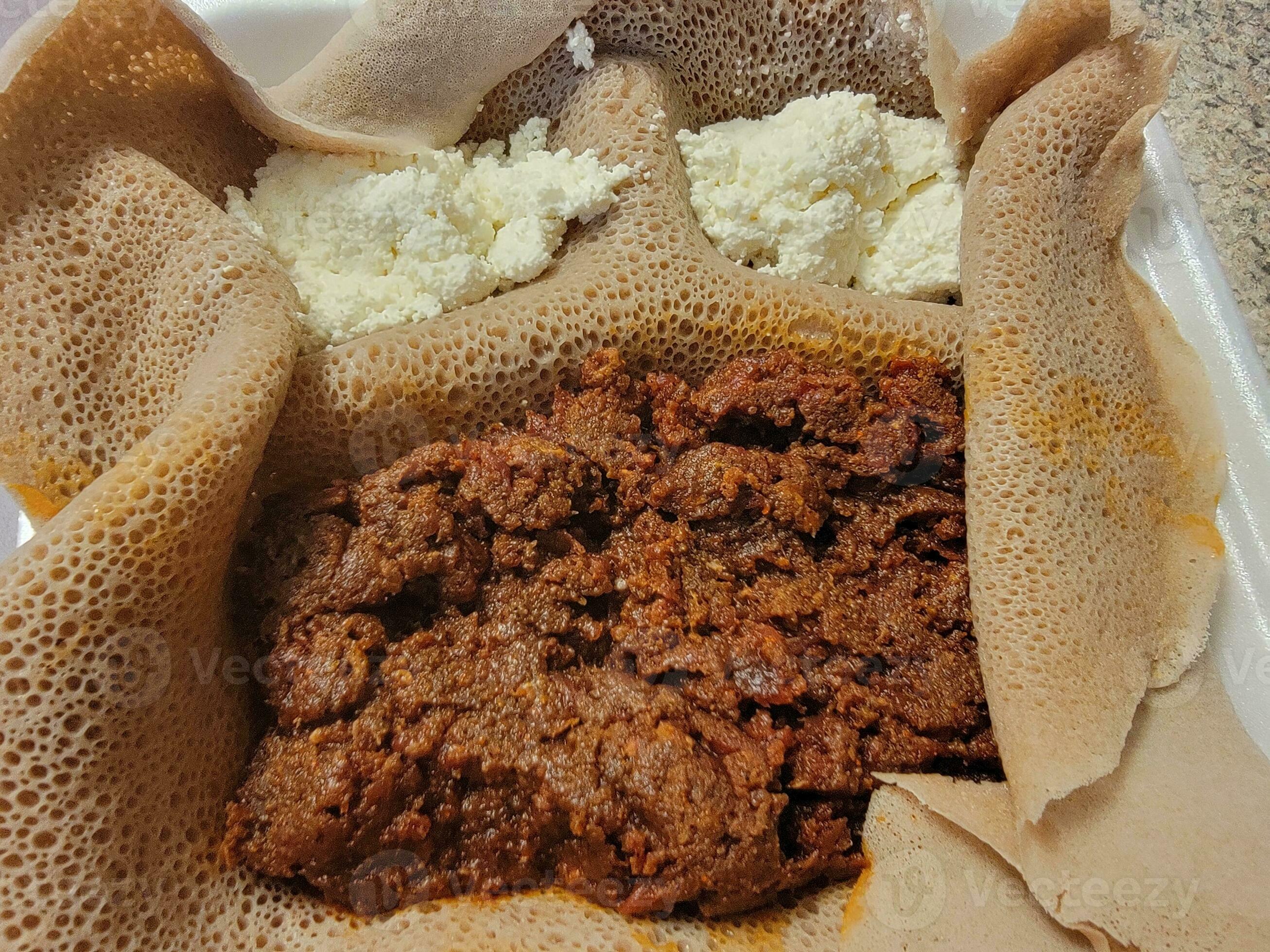 Ethiopian food kitfo raw beef with injera bread and cheese 8200266