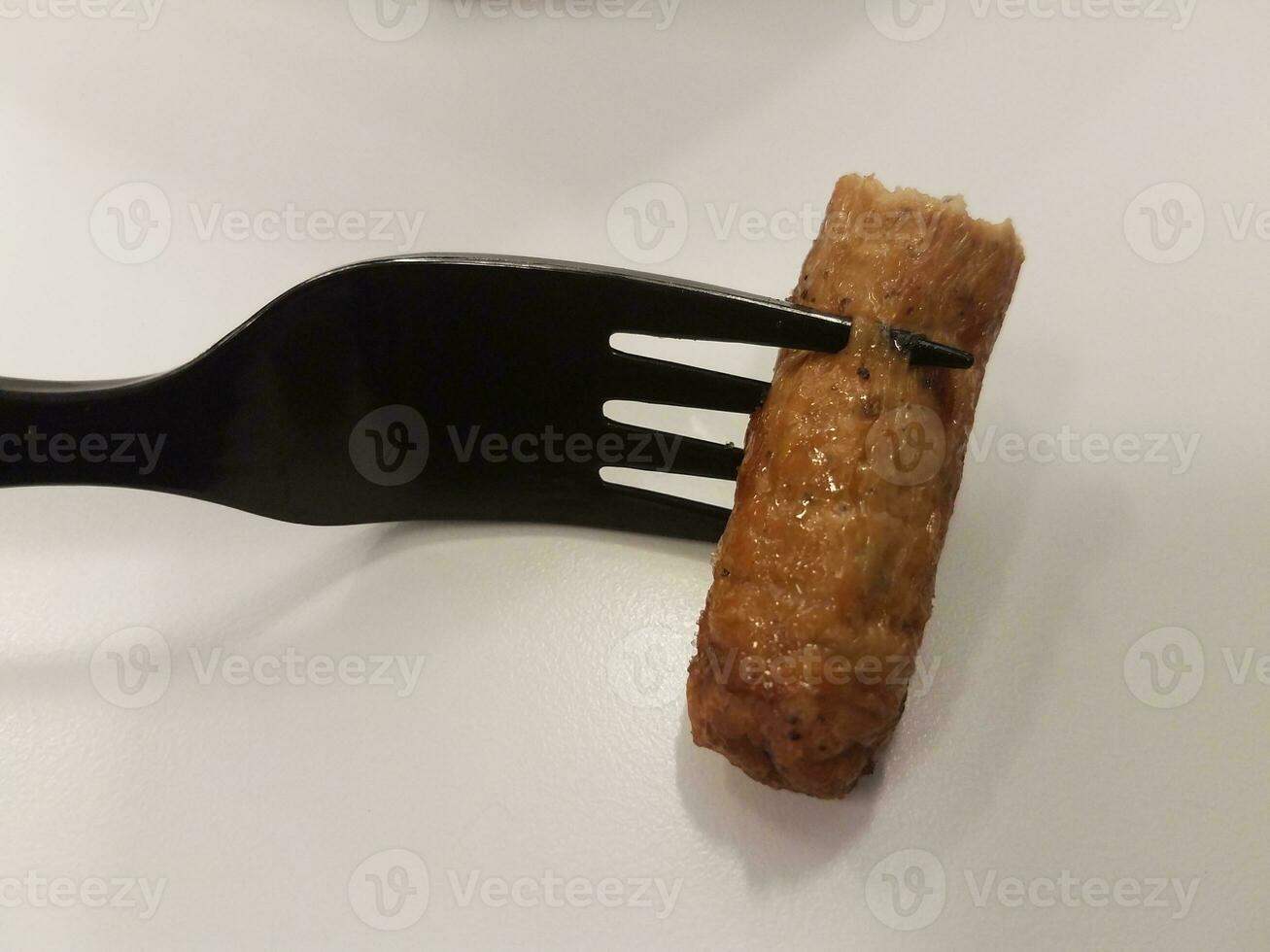 black fork and sausage on white surface photo