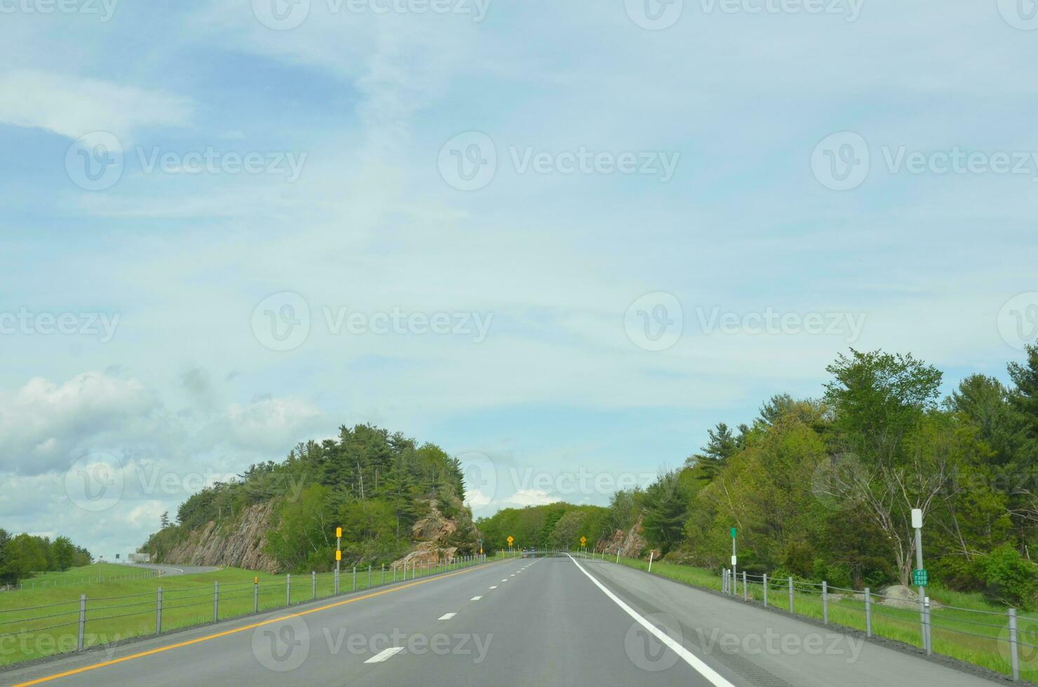 camino cuesta arriba con árboles y nubes y cielo foto