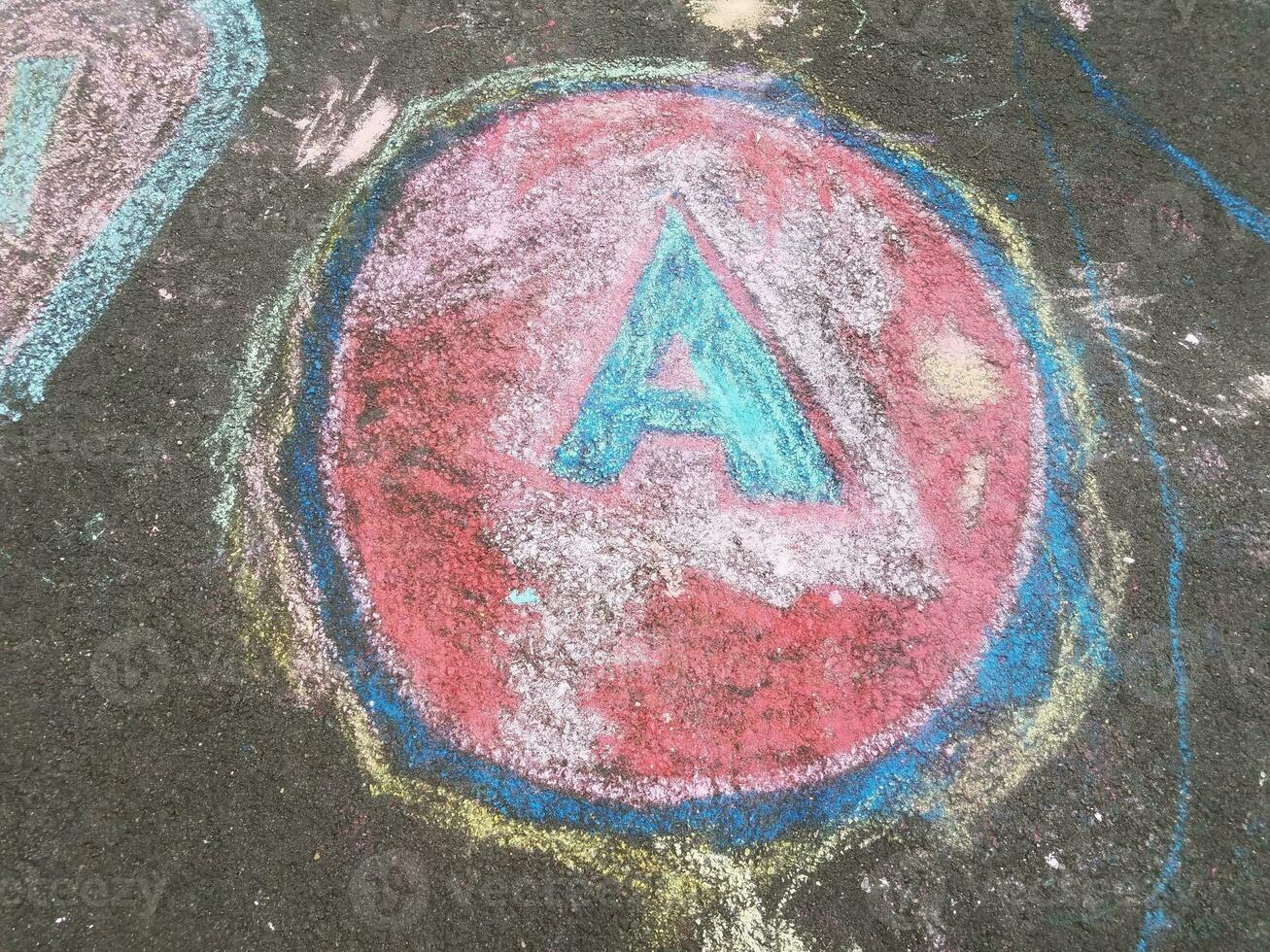 un círculo azul y rojo con la letra a hecha de tiza foto