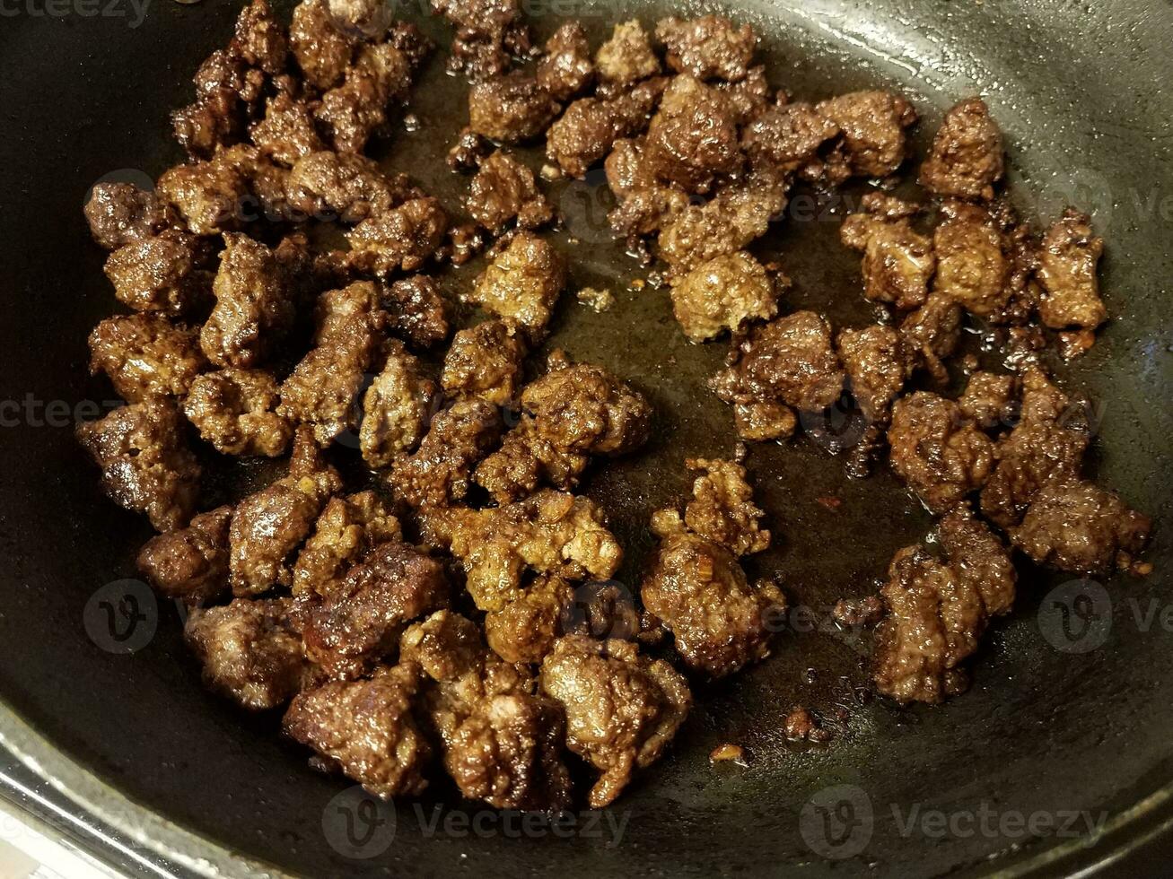 ground beef cooking in frying pan with oil photo