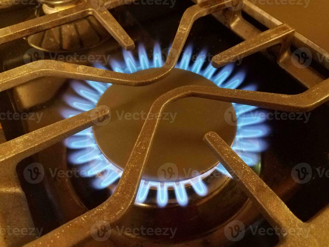 blue flame on natural gas stove top with metal grate photo