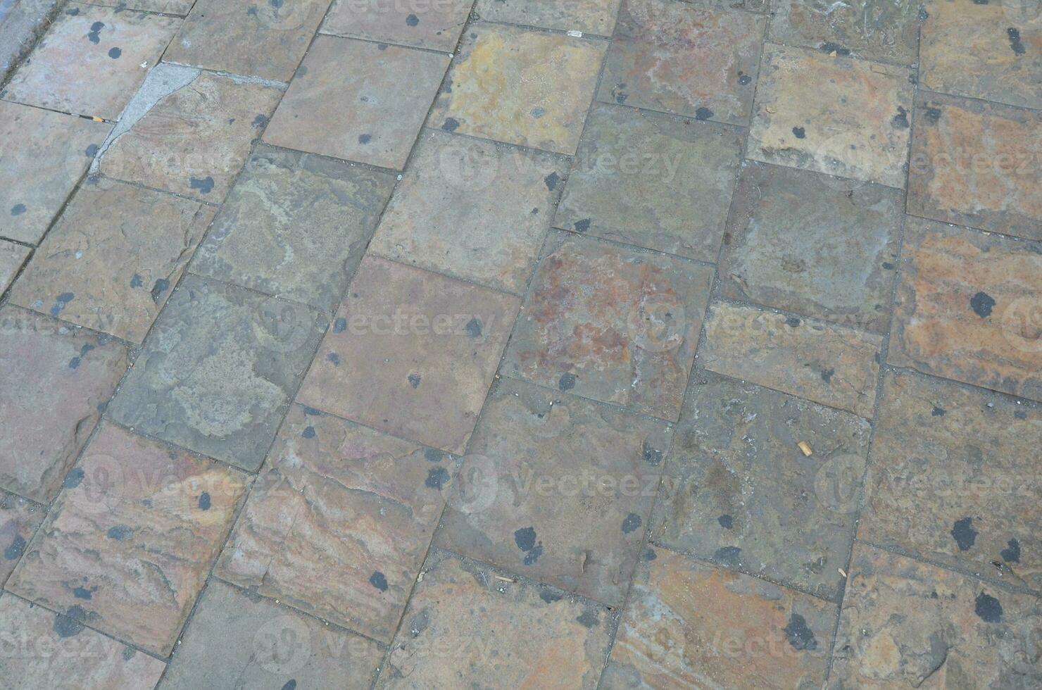 black old gum and cigarette butts on stone tiles photo