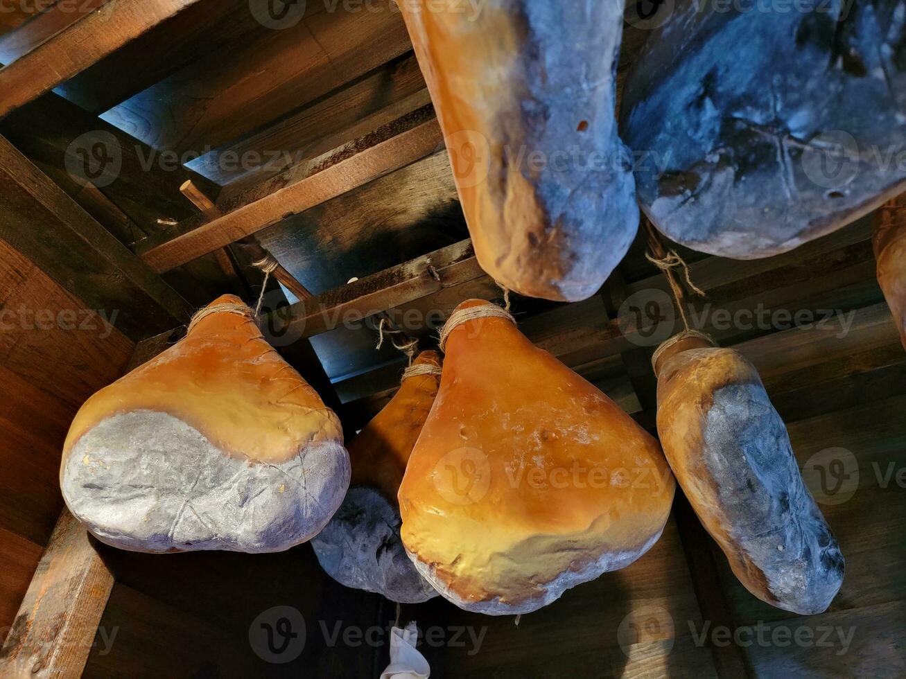 chunks or large pieces of ham hanging from ceiling photo