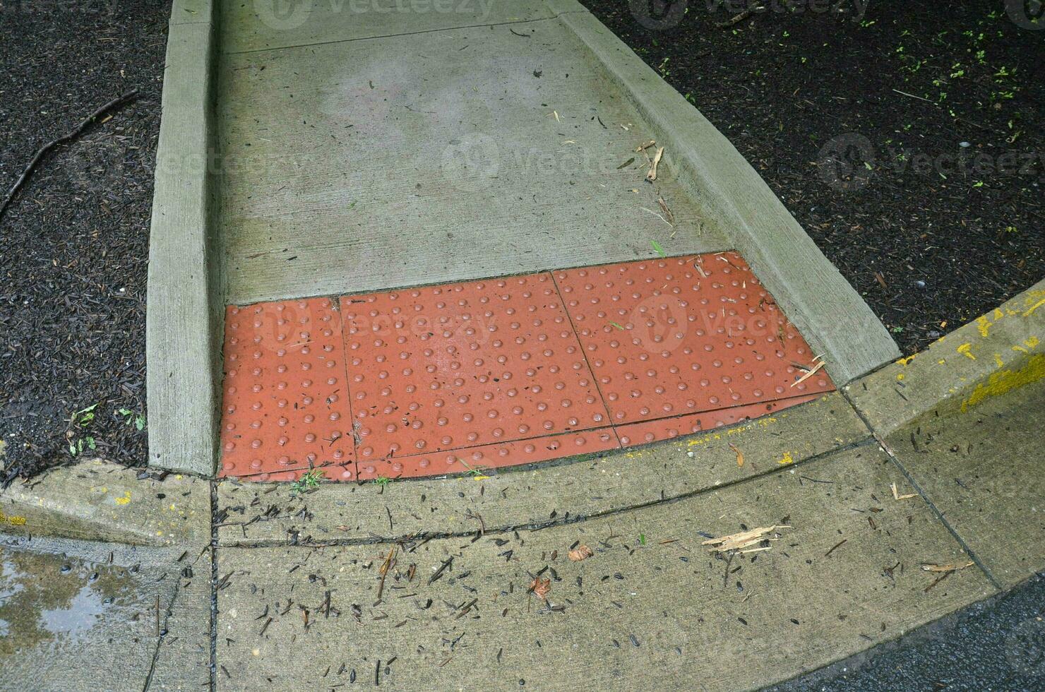 cement sidewalk with red bumps for the blind photo