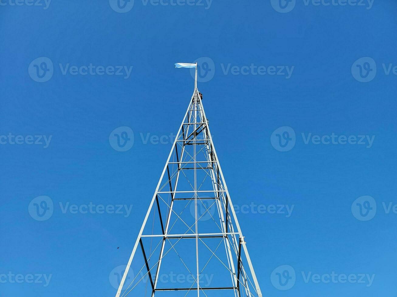 tall metal tower or structure with blue and white flag photo