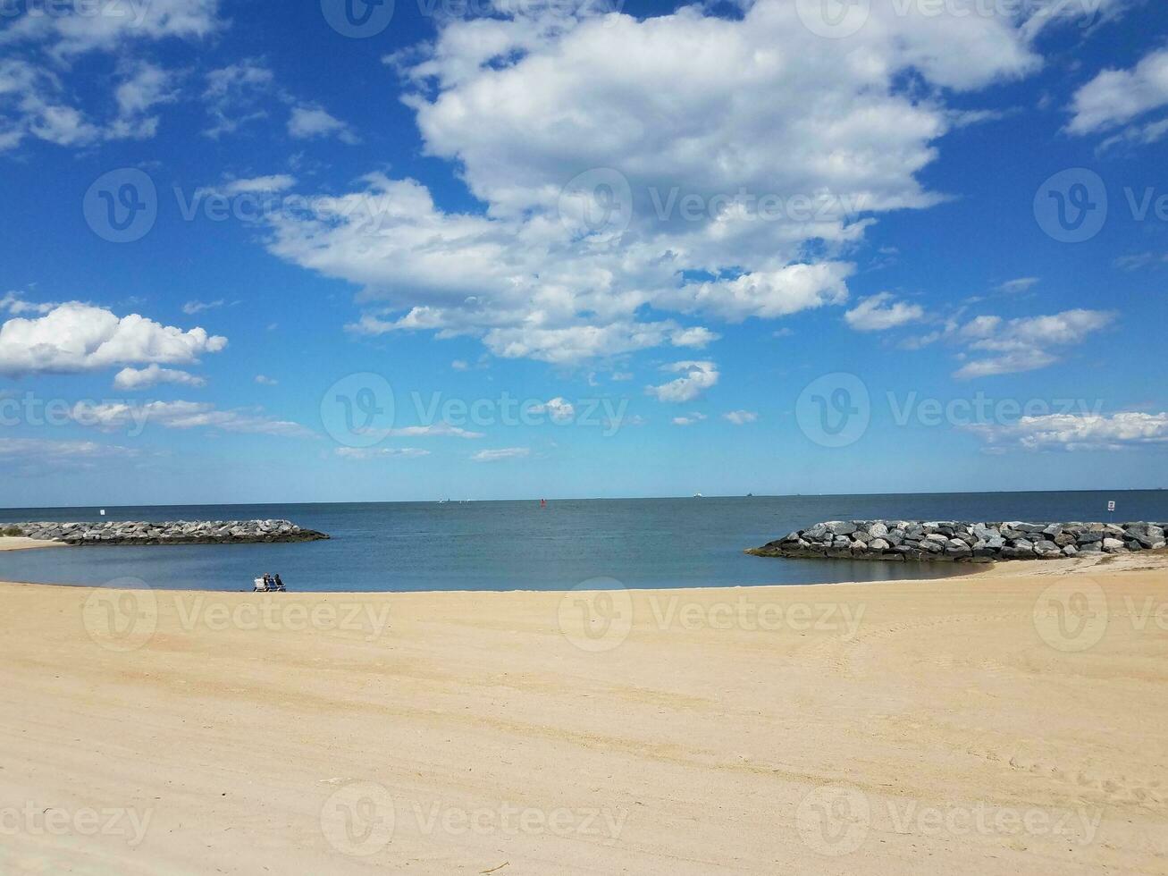 sand and rocks and water and clouds at beach photo