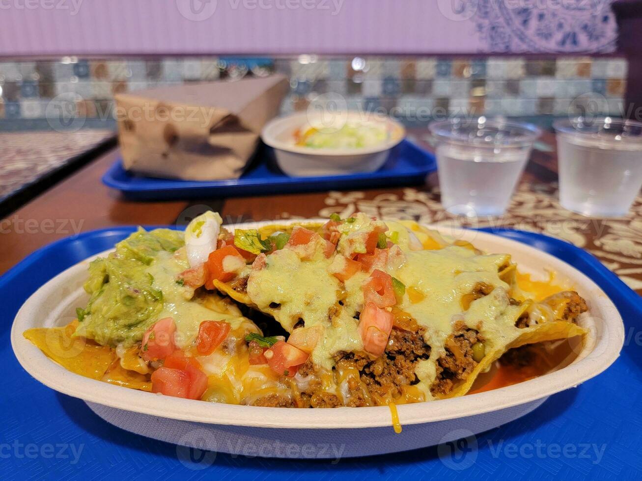 Mexican nachos on plate with avocado and salsa and cheese photo