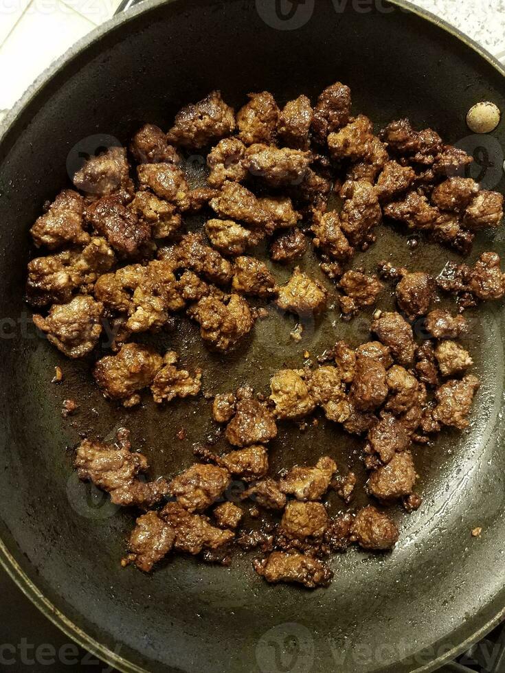ground beef cooking in frying pan with oil photo