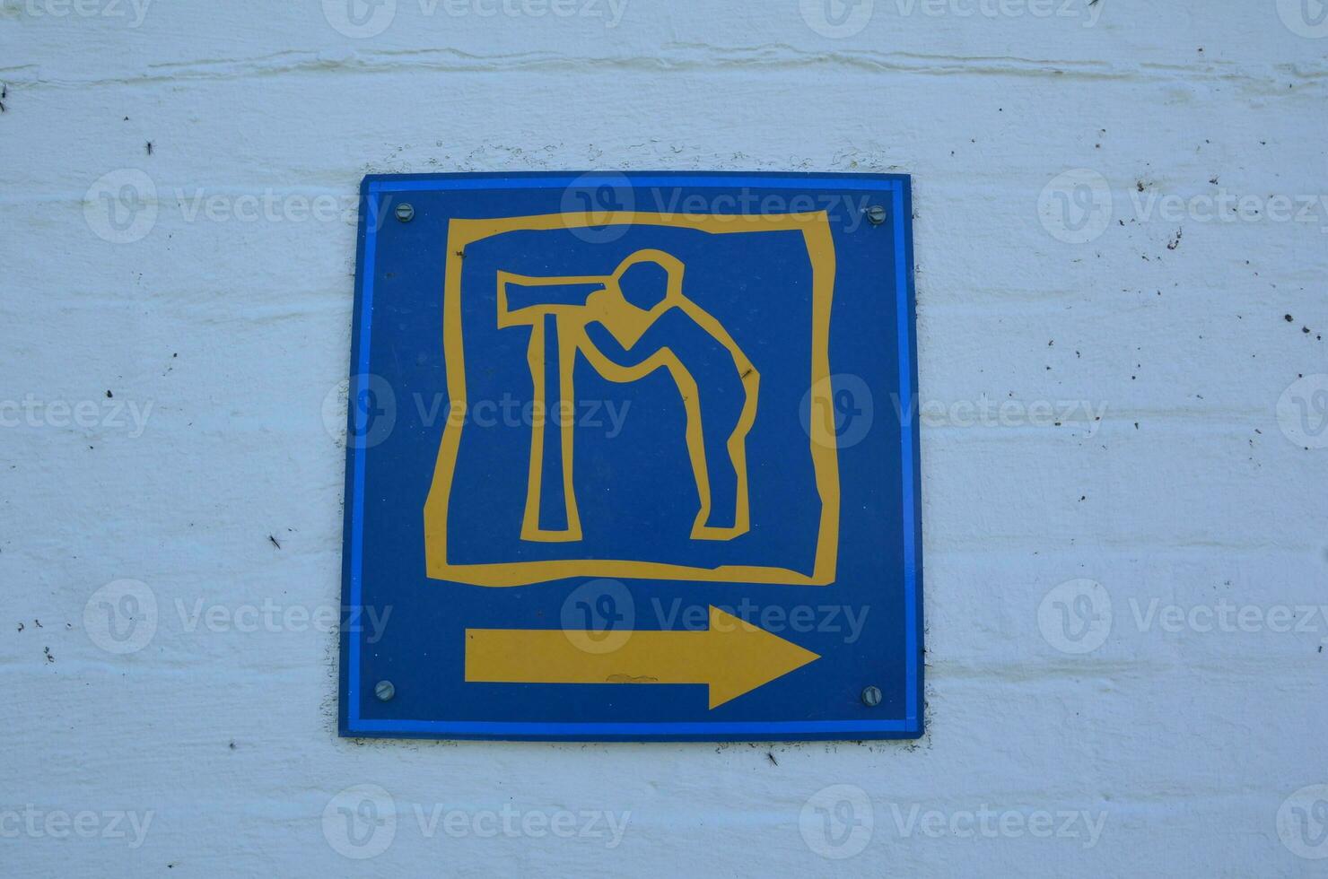 blue and yellow telescope sign on white wall photo