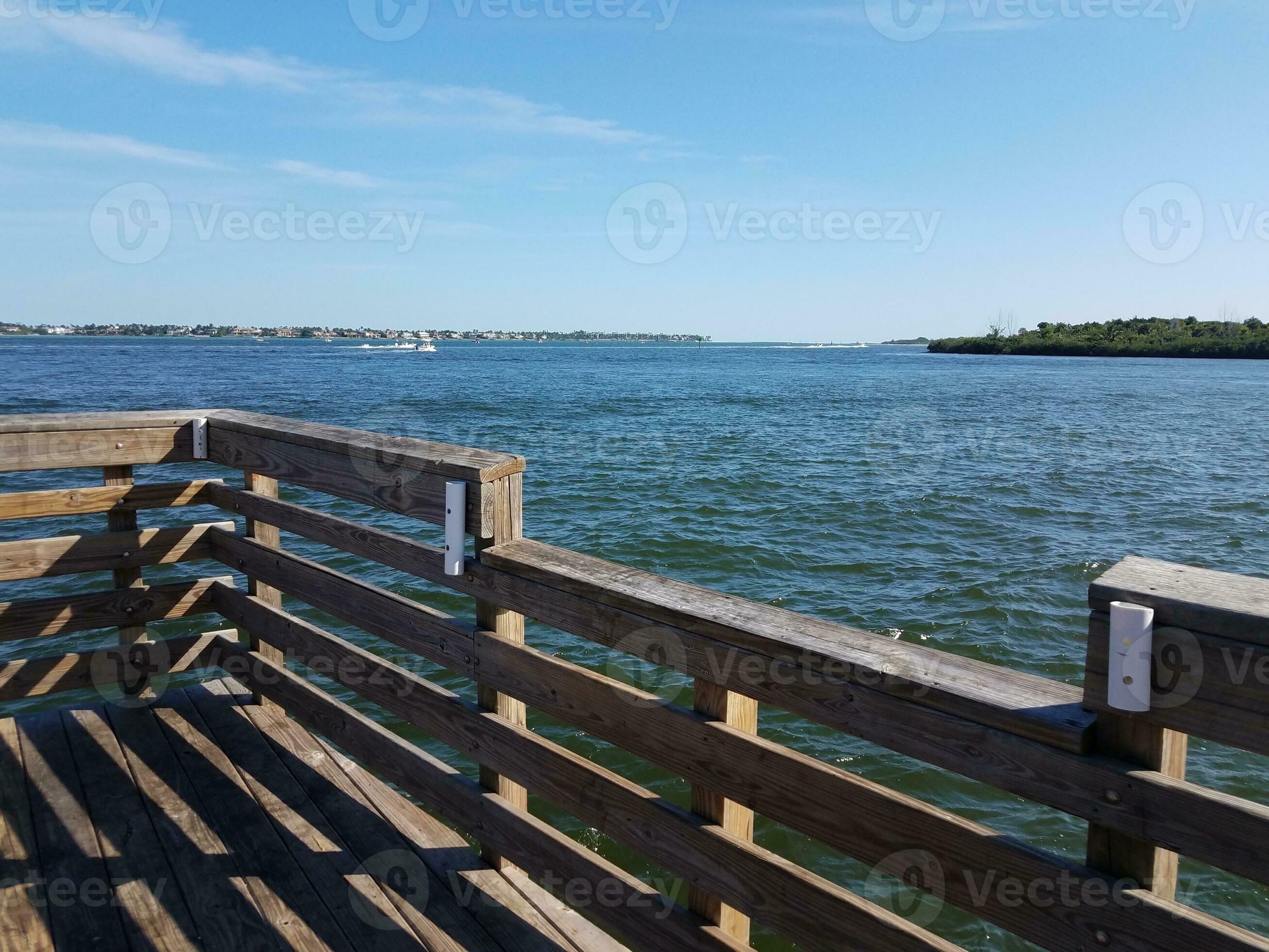plastic fishing rod holder on wood railing with water 8201633 Stock Photo  at Vecteezy