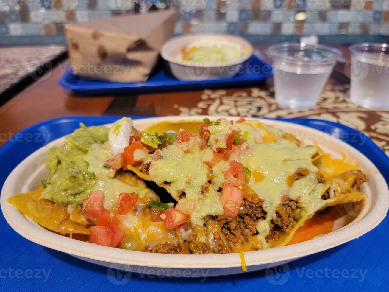 Mexican nachos on plate with avocado and salsa and cheese photo