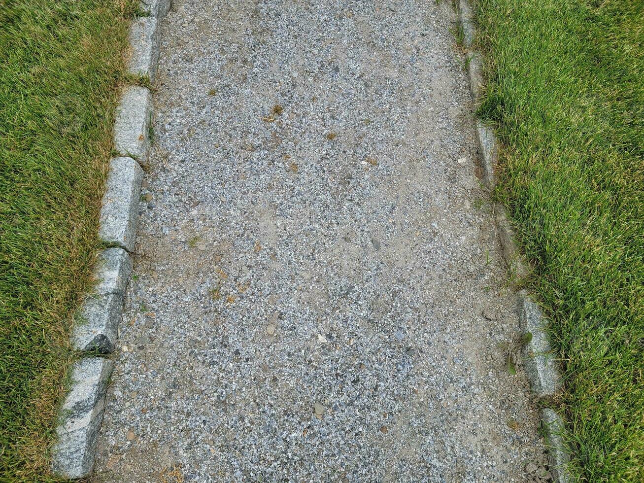 grey stone or gravel path with green grass or lawn photo