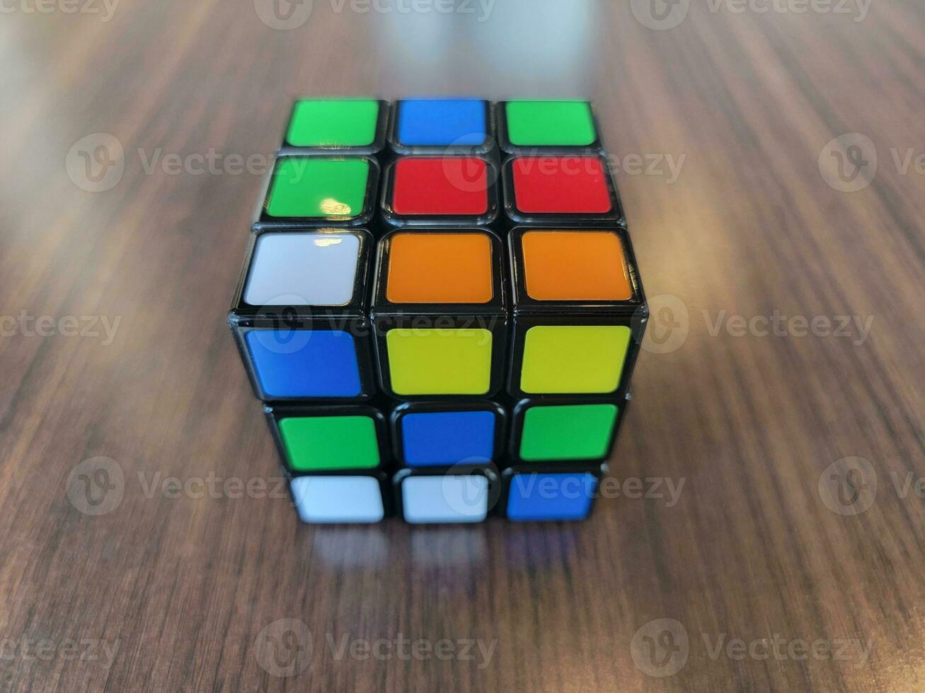 colorful cube of squares on brown wood table photo