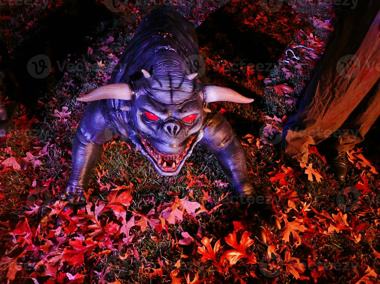 monster with red eyes and horns on ground photo