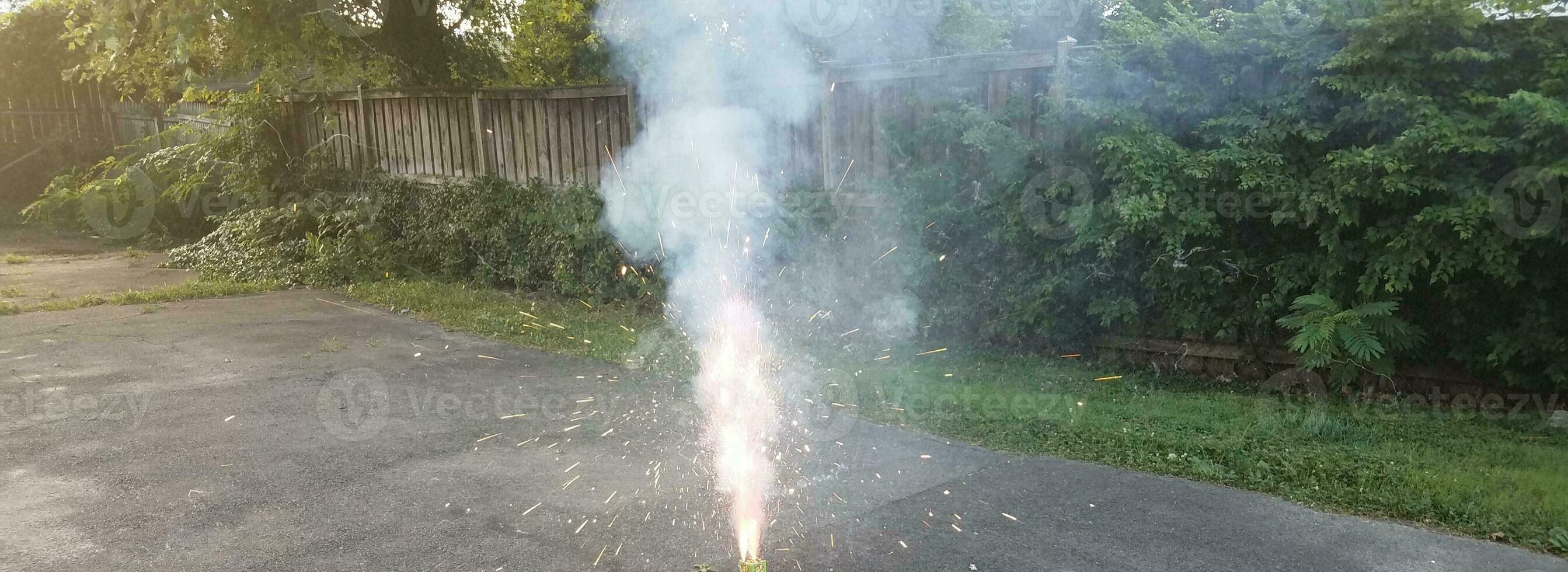 fuegos artificiales de colores encendidos en la entrada de asfalto con humo foto