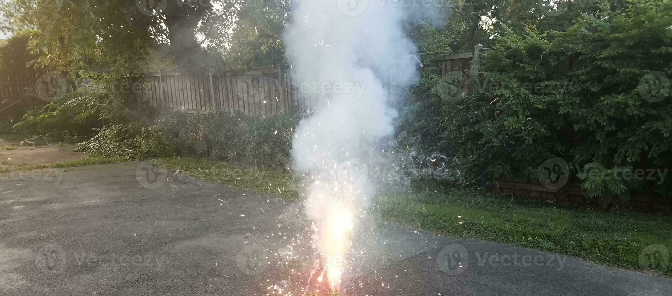 fuegos artificiales de colores encendidos en la entrada de asfalto con humo foto