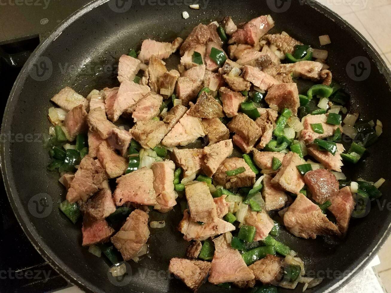 beef and hot peppers and onions in frying pan photo