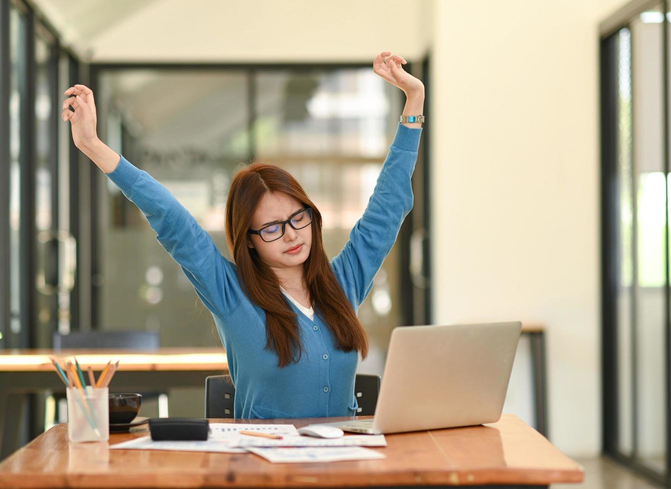 Woman stretches her arms when tired in the office, business woman relaxes, office syndrome. photo