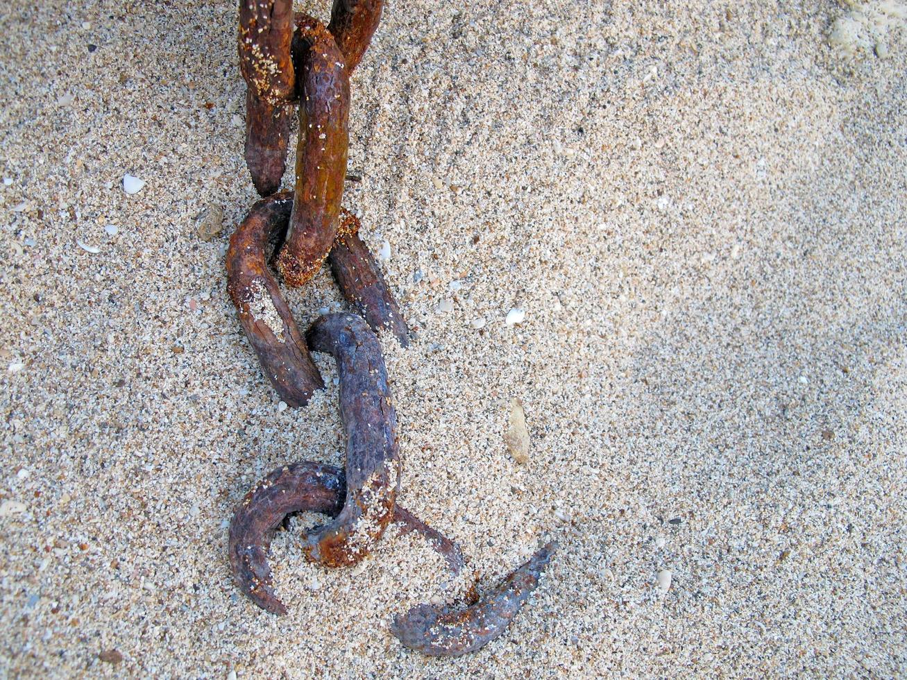 rusty chain on sand beach. photo