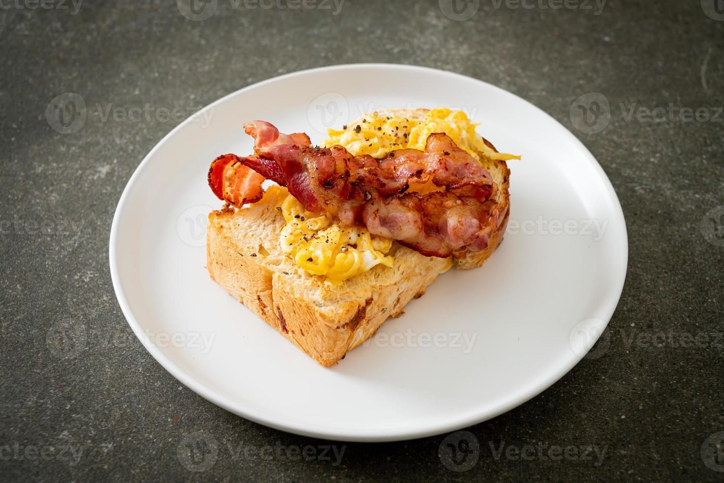 tostada de pan con huevos revueltos y tocino foto