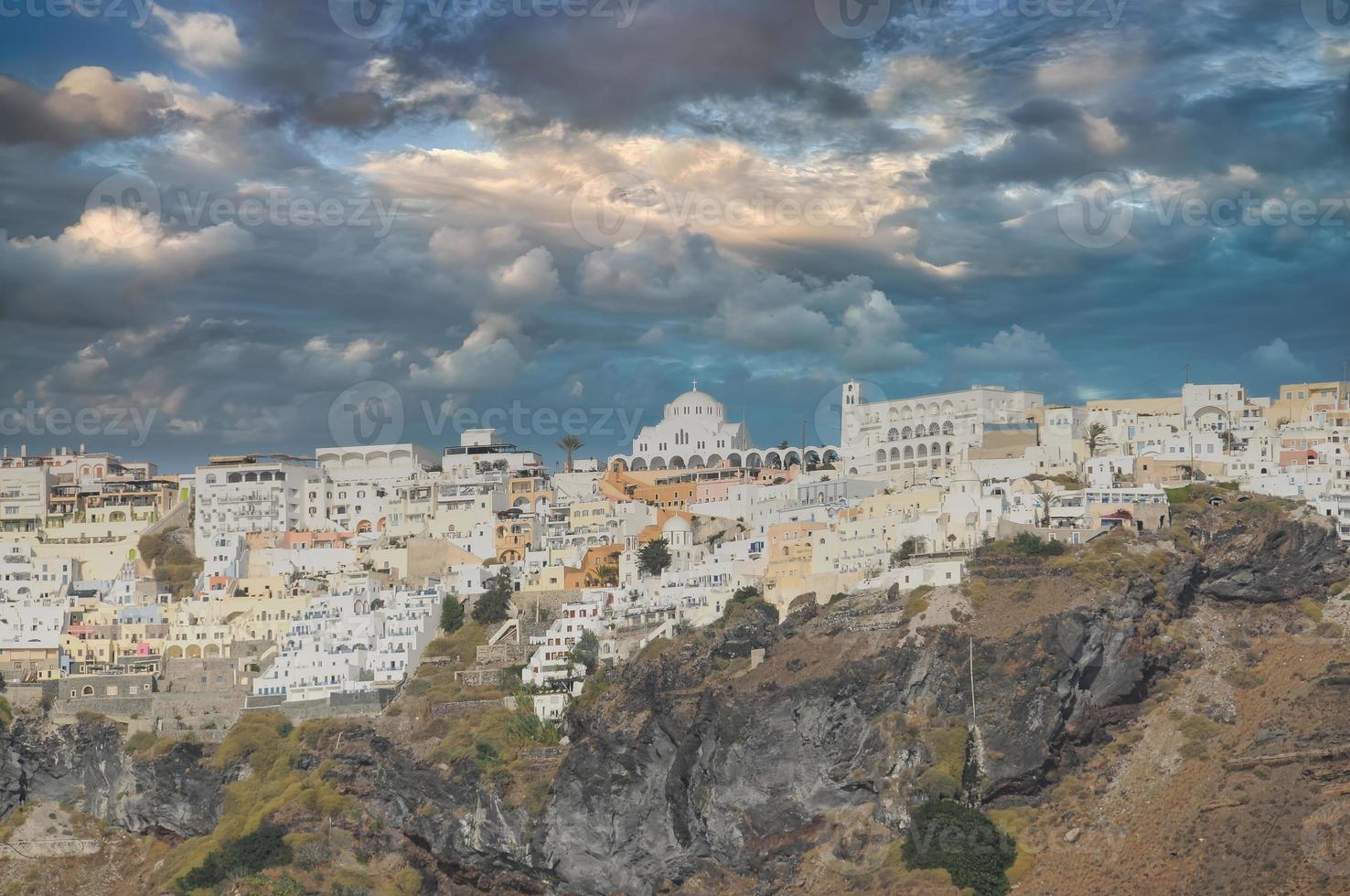 Oia town on Santorini island, Greece. Traditional and famous houses and churches with blue domes over the Caldera, Aegean sea photo