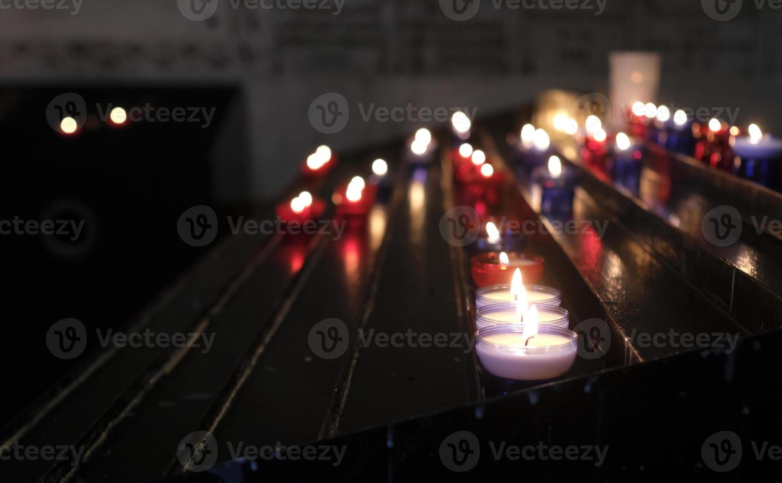Many small candles illuminating a dark church room photo