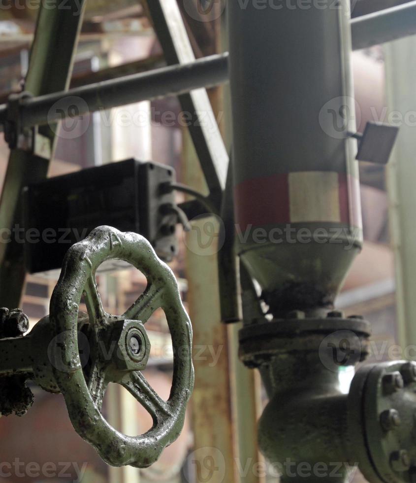 Weathered valve in abandoned steel factory photo