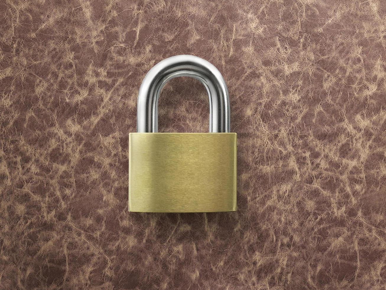 golden closed lock on a brown leather background photo