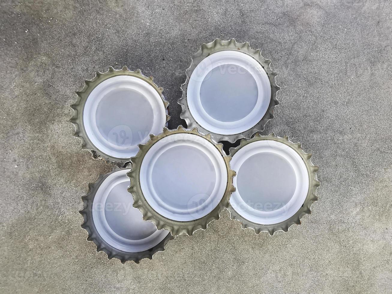 Tapa de botella de refresco aislada en el piso de cemento foto