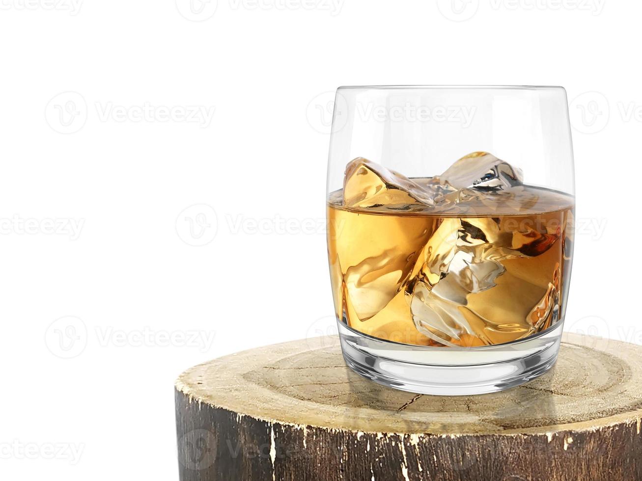 vaso de whisky en un viejo tronco de madera foto