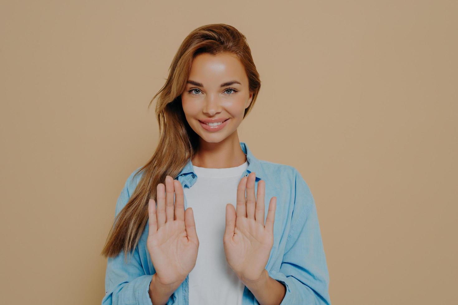 Joyful pretty model making stop sign using hands photo