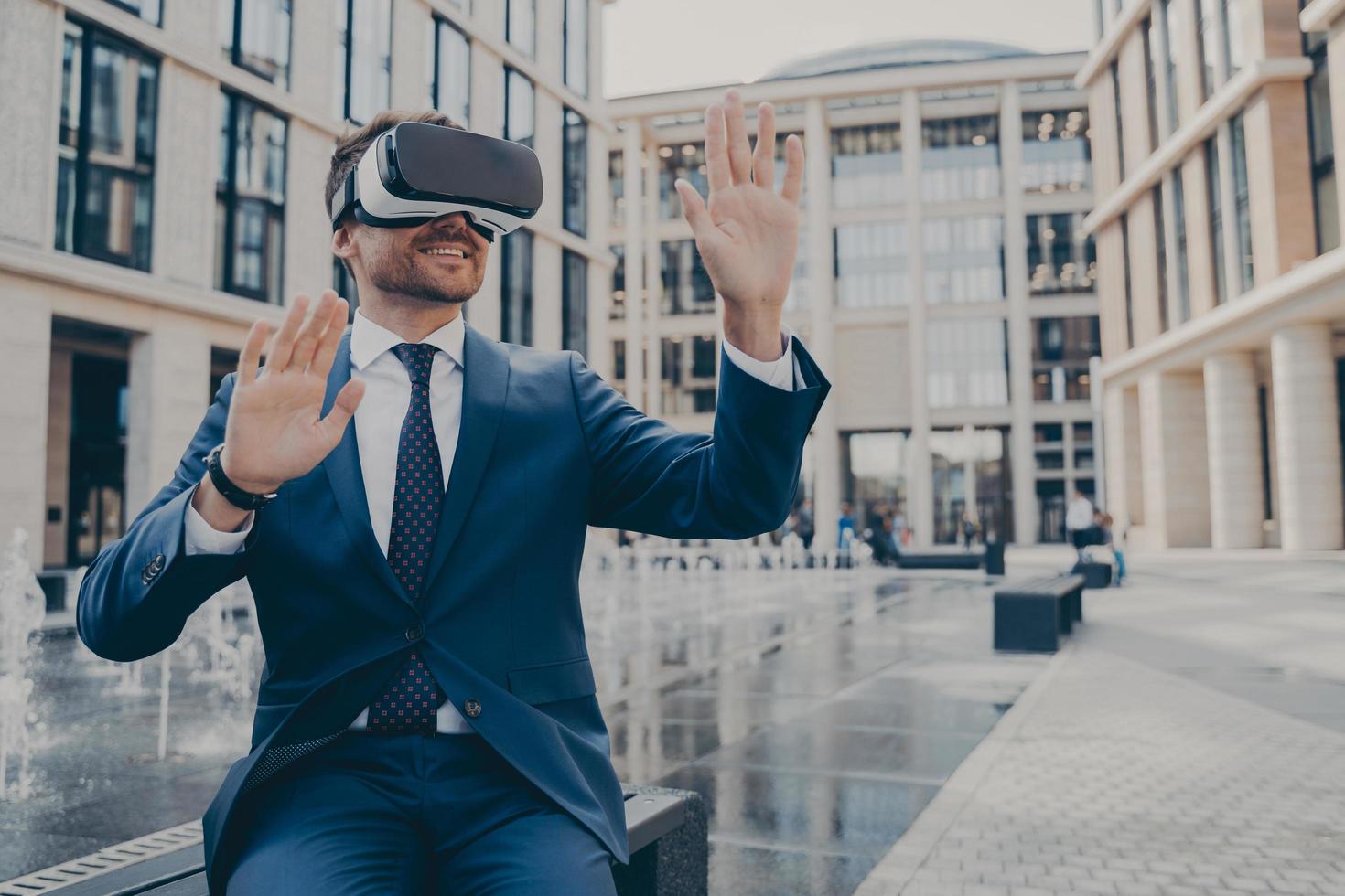 Successful young businessman in formal suit viewing future project in virtual reality photo