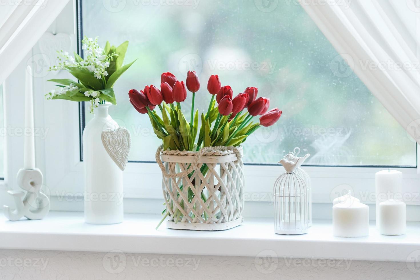 red tulips and snowdrops in basket on box photo