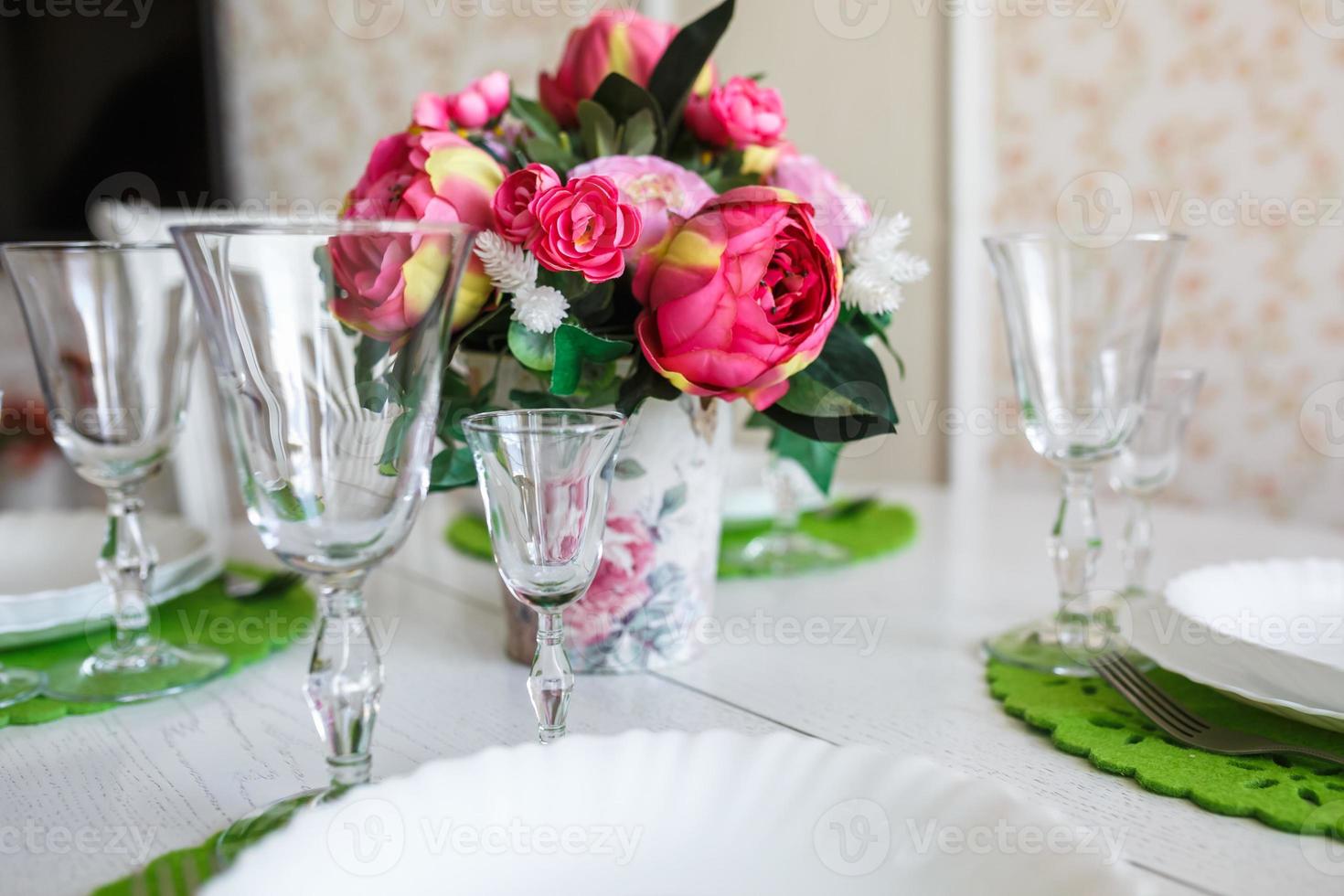 ramo de flores de peonías rosas en una mesa con cubiertos foto