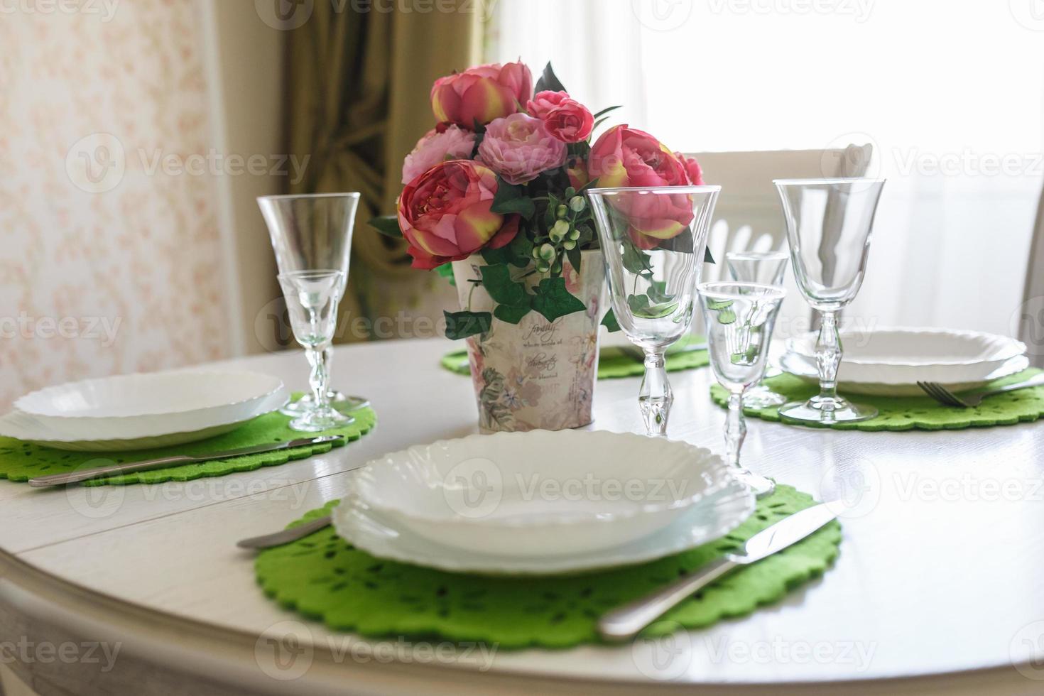Bouquet of pink peonies flowers on a table with cutlery photo