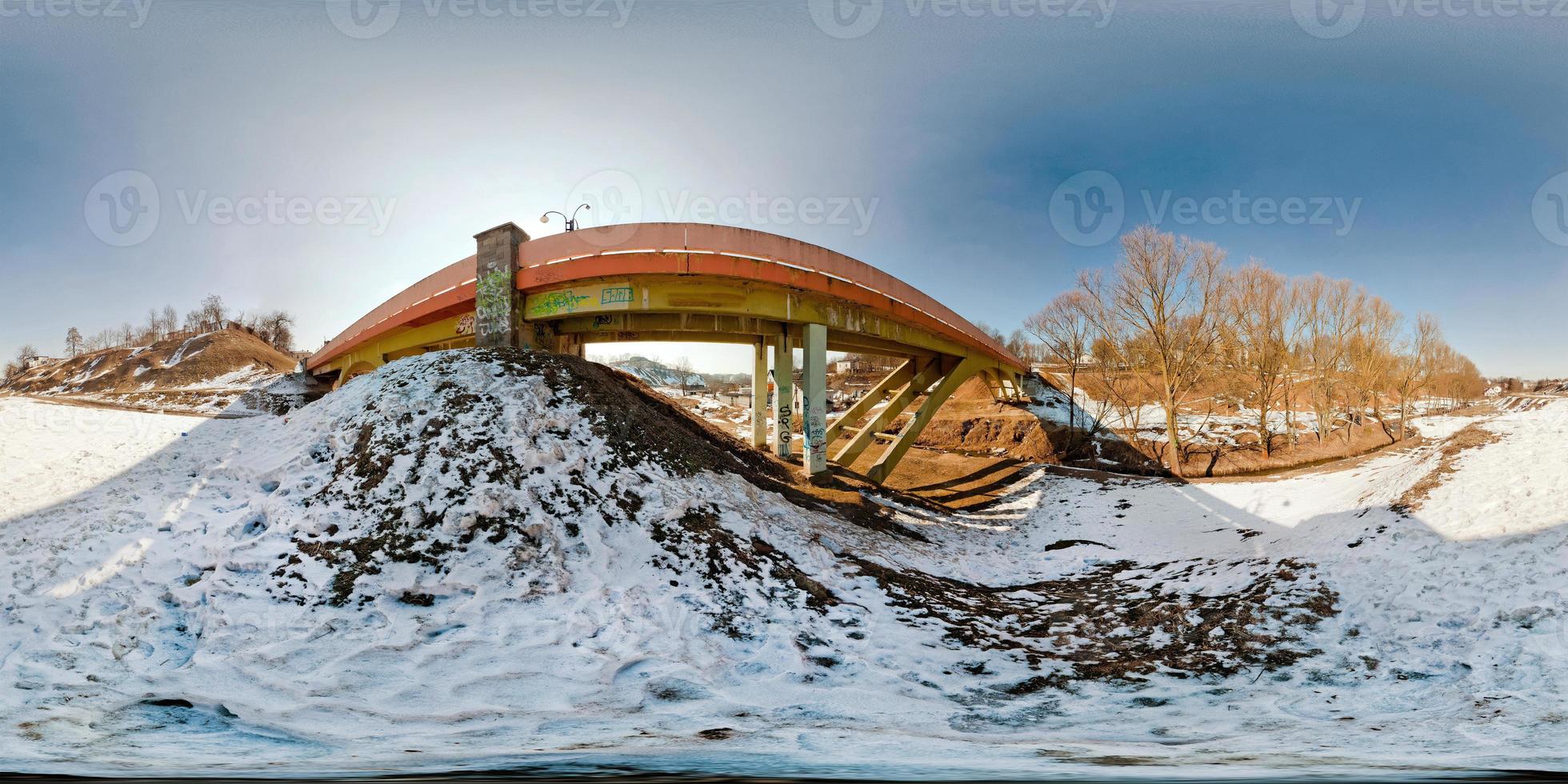 Winter panorama in the snow-covered forest near the bridge in nice sunny evening. Full spherical 360 by 180 degrees seamless panorama in equirectangular projection. Skybox for Virtual reality content photo