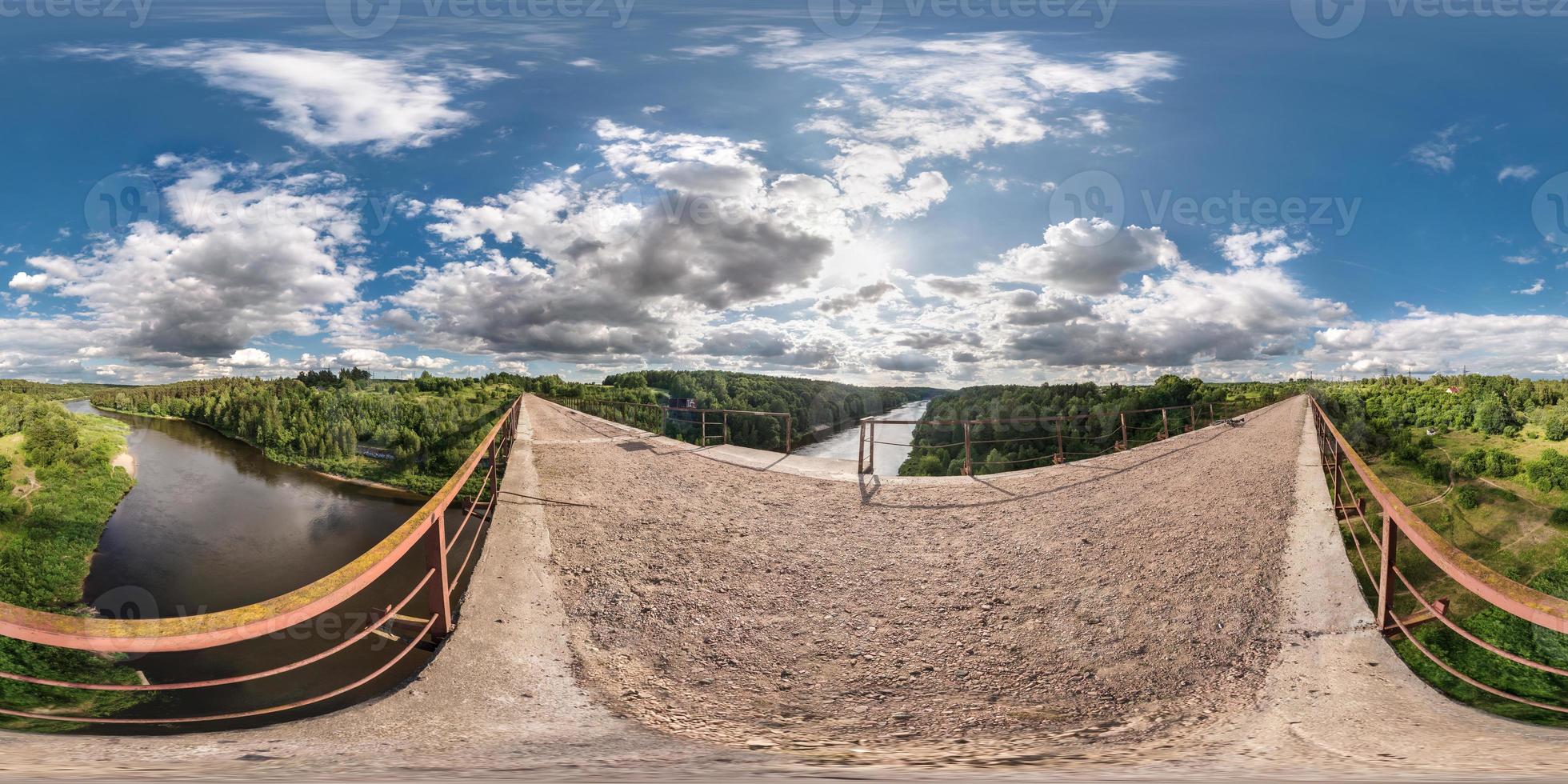 full 360 degree seamless panorama in equirectangular spherical equidistant projection. Panorama view on abandon bridge near river with nice clouds. Skybox as background for virtual reality content photo