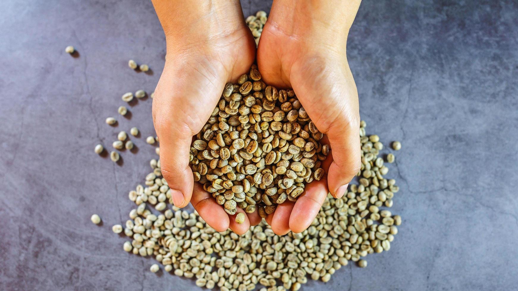 Organic green coffee beans in hand photo