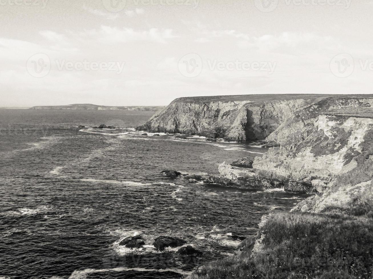 Beautiful view of a sea surrounded by cliffs under a bright sky photo