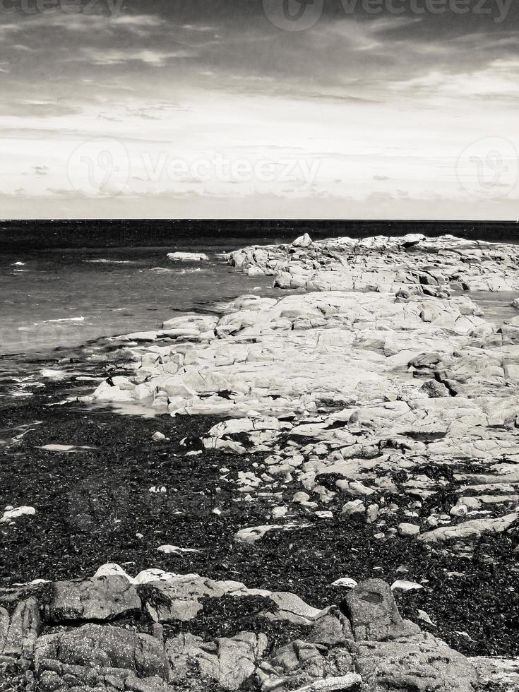 Beautiful view of a sea surrounded by cliffs under a bright sky photo